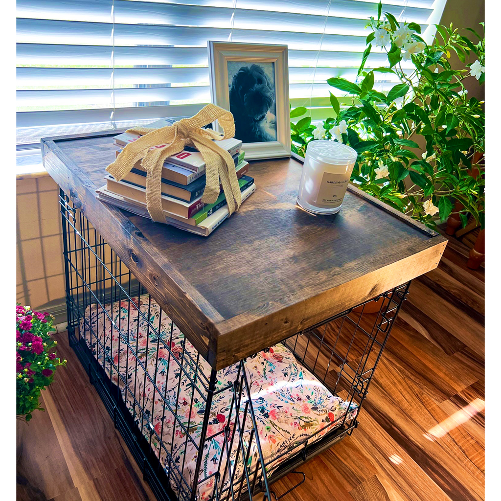 Wooden crate with a wooden top, books, a candle, and a plant on a wooden floor. wooden crate topper, wooden kennel topper, dog crate table, dog kennel table, dog crate cover, dog crate furniture, dog crate end table, dog kennel furniture, dog bed furniture, wooden dog furniture, wood table dog crate, wooden dog kennel furniture, pet furniture wood pet furniture
