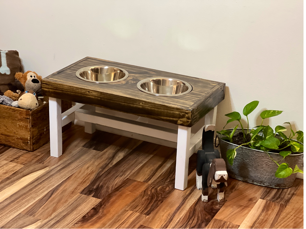 Wooden pet feeding station with two bowls on a wooden floor. Raised dog bowl stand, dog bowl holder, large dog bowl stand, small dog bowl stand, wooden dog bowl stand raised, elevated pet bowl stand, elevated dog bowl stand, dog bowl stand wood,