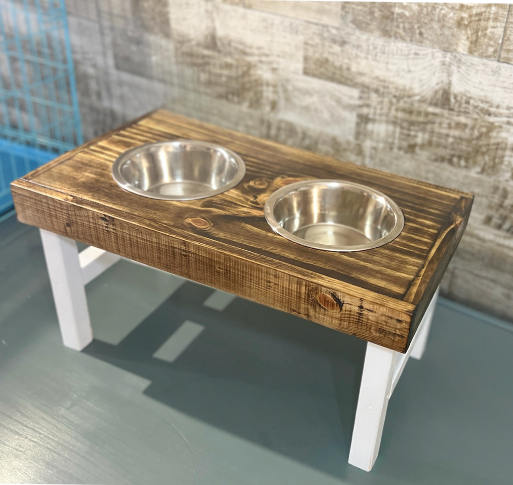 Wooden pet feeding station with two bowls on a wooden floor. Raised dog bowl stand, dog bowl holder, large dog bowl stand, small dog bowl stand, wooden dog bowl stand raised, elevated pet bowl stand, elevated dog bowl stand, dog bowl stand wood,
