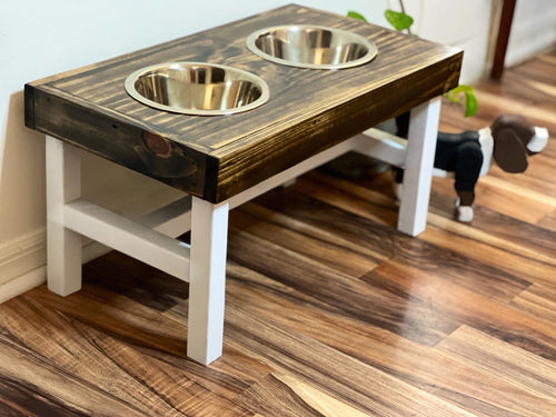 Wooden pet feeding station with two bowls on a wooden floor. Raised dog bowl stand, dog bowl holder, large dog bowl stand, small dog bowl stand, wooden dog bowl stand raised, elevated pet bowl stand, elevated dog bowl stand, dog bowl stand wood,